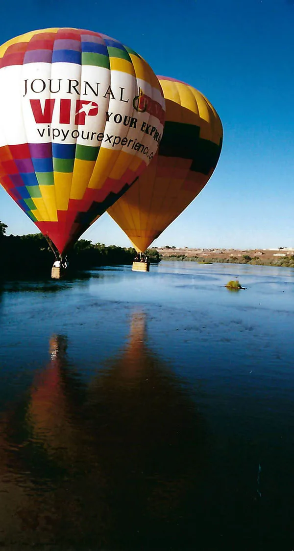 The Reflections And Shadows Of Hot Air Balloons In Flight Over The Rio Grande River